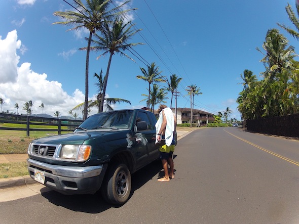 Man getting into a green truck on a hawaii street