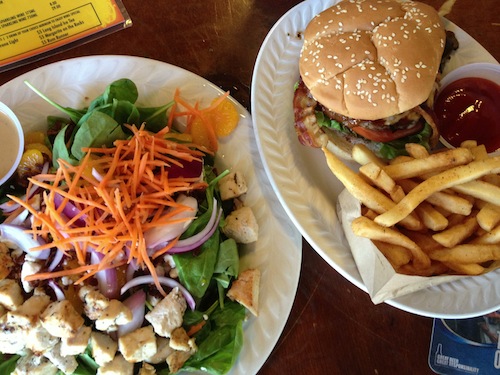 A burger with fries and a chicken salad