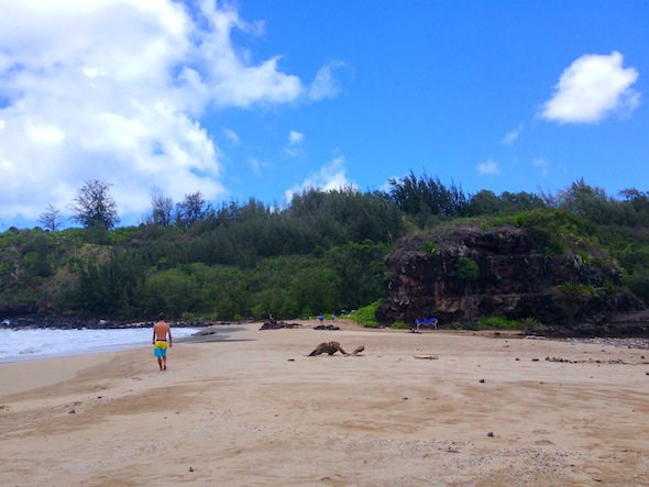 A man walks on the beach at Lawai Bay