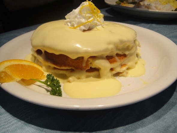 A plate of pancakes covered with white syrup