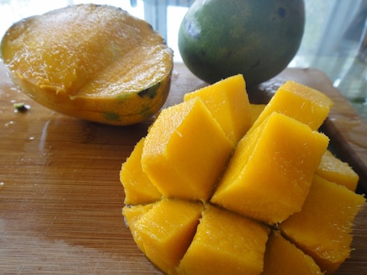 A mango that has been sliced int cubes with the skin on