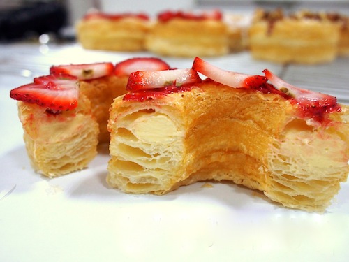 A plate of cronuts drizzled with strawberry sauce