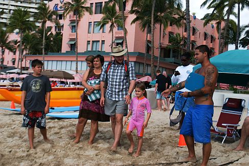 Family on Waikiki Beach receives tips from Beach Boy