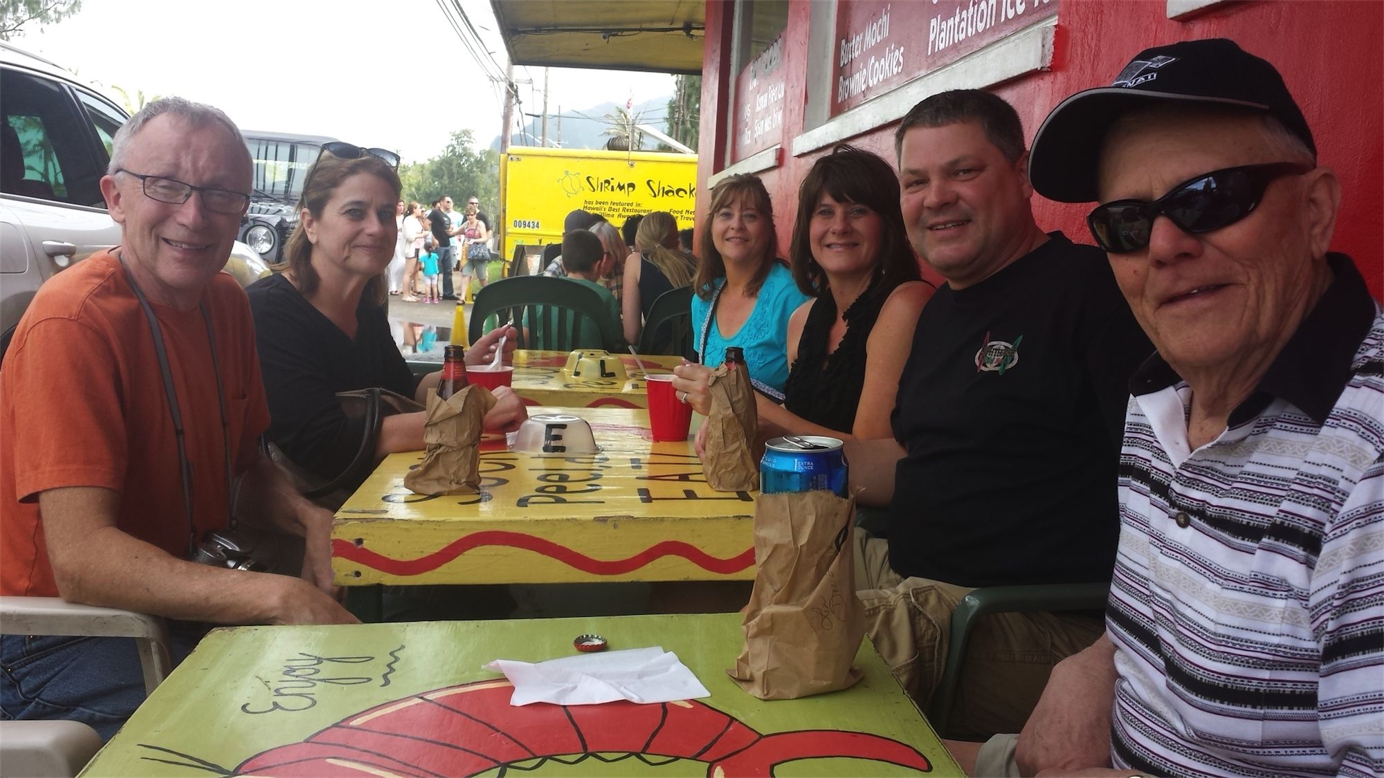 A group of people seated at a table in front of North Shore Food Trucks