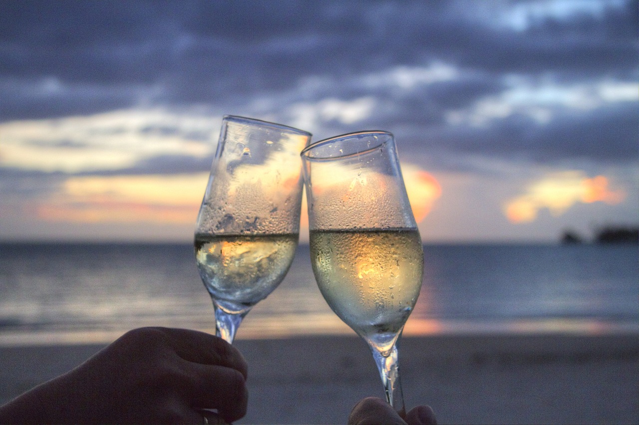 2 glasses of wine held up on a sunset