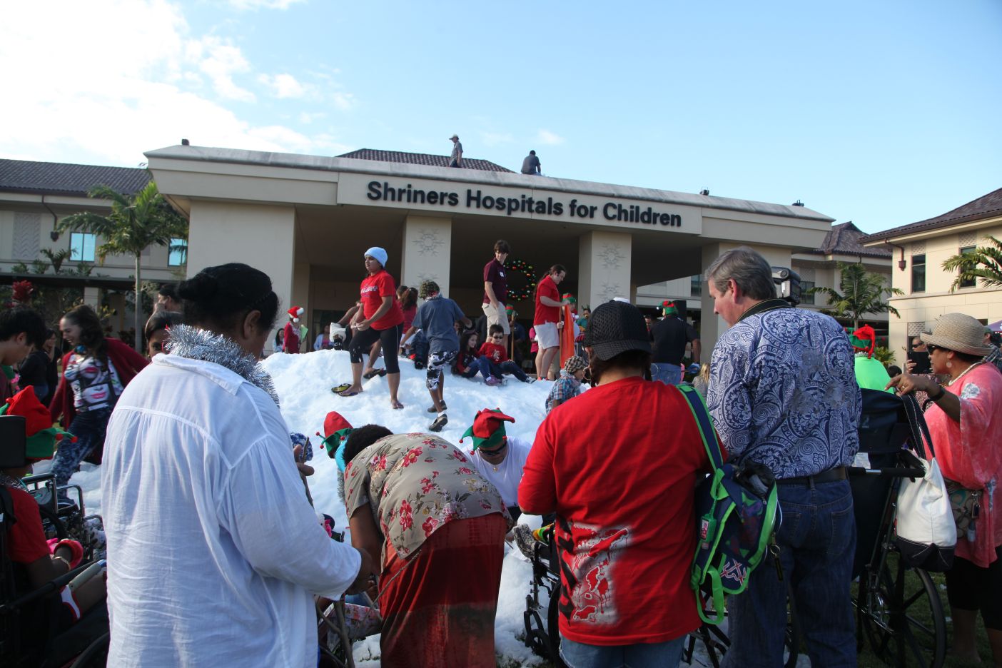 people playing in snow in front of Shriners hospital in Hawaii on Oahu