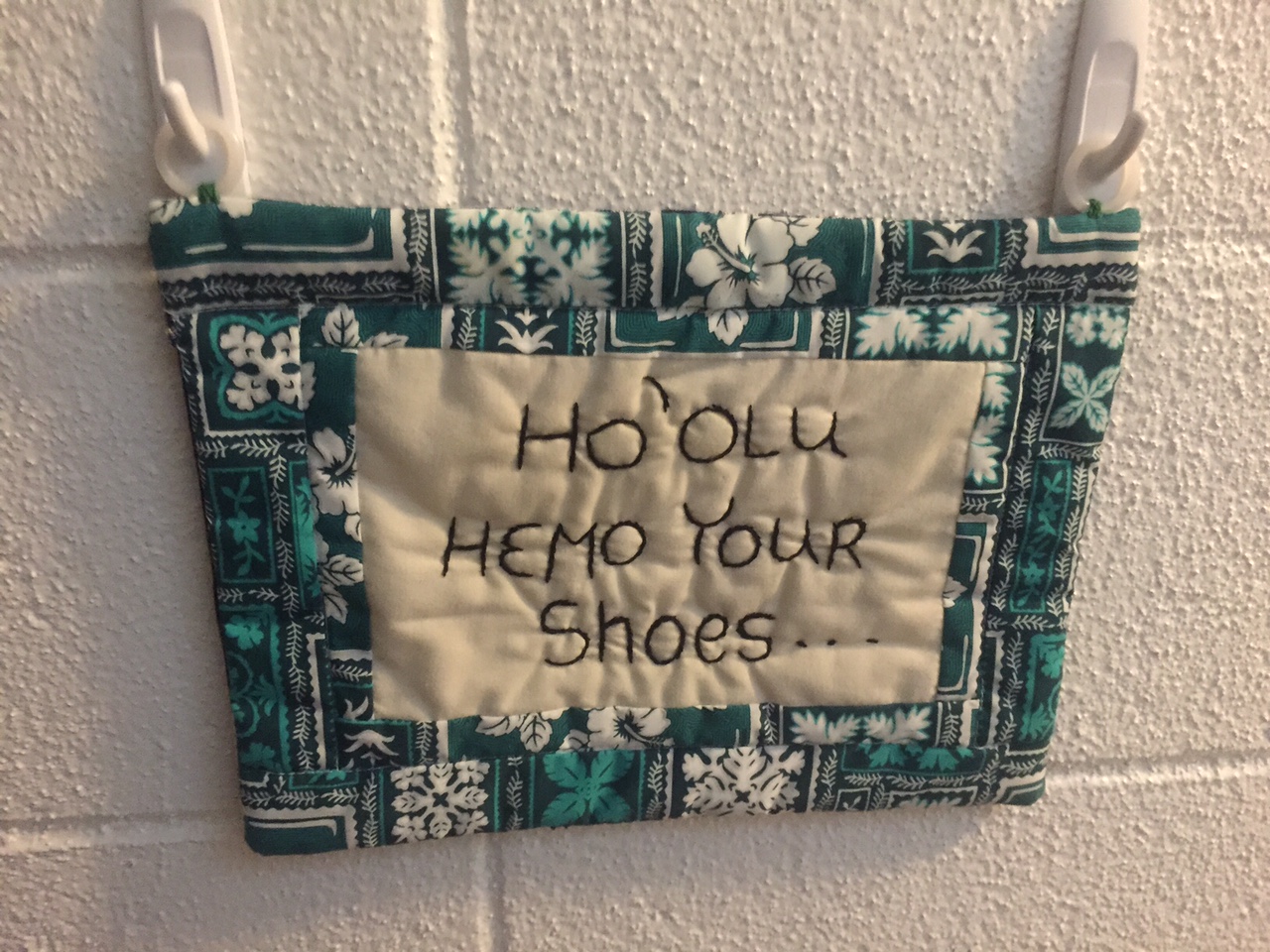 sign asking guests to remove their shoes in hawaiian