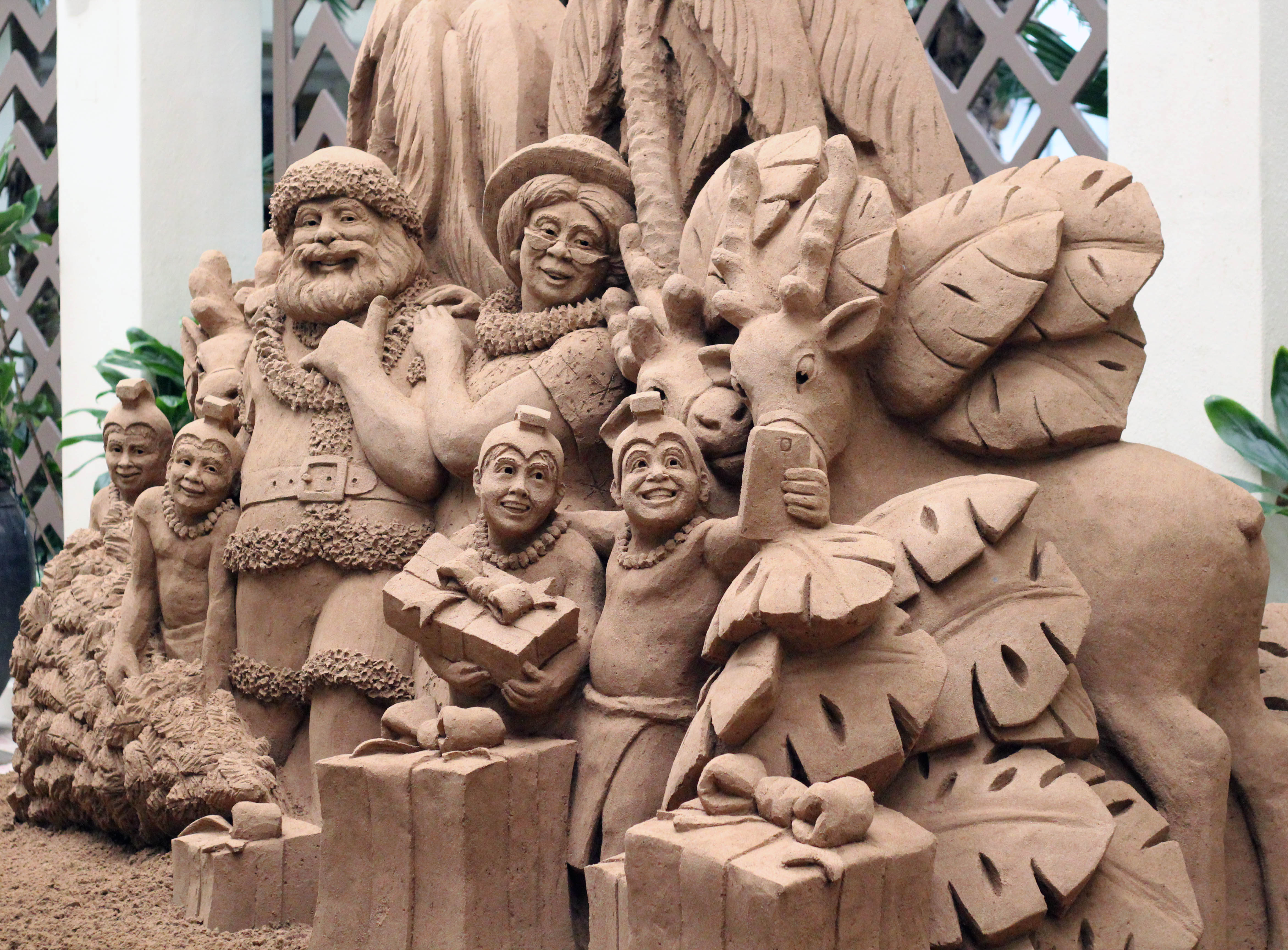 a sand sculpture of santa claus taking a selfie