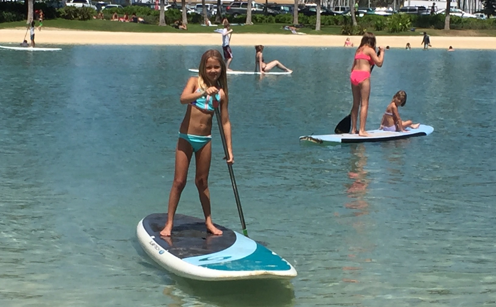 a young girl stand-up paddleboarding