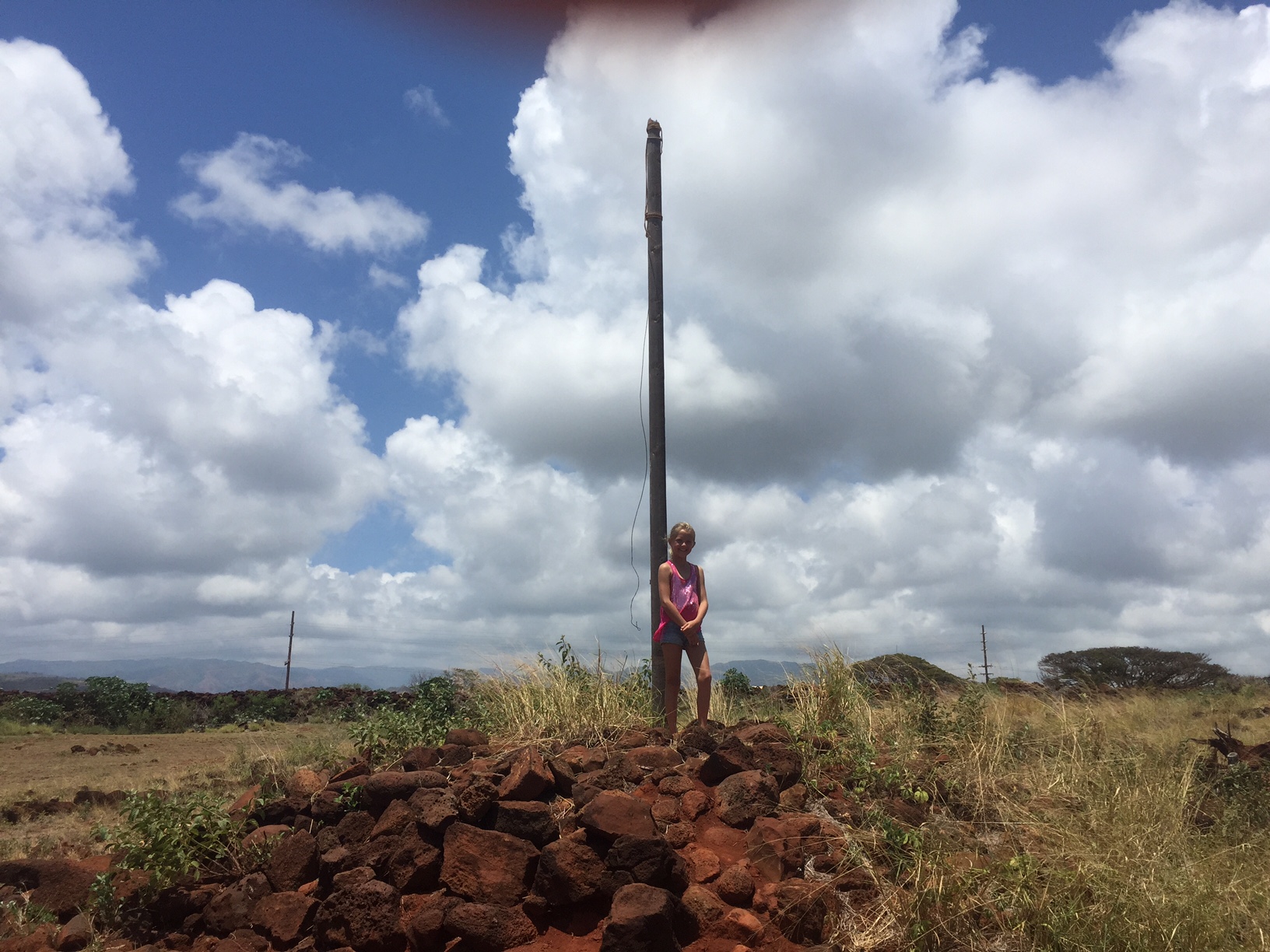 a girl standing by a flagpole