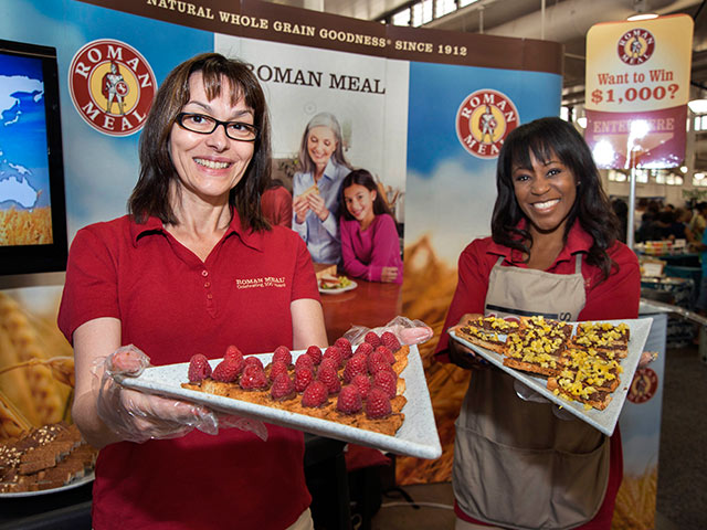 two women offering treats on a plate