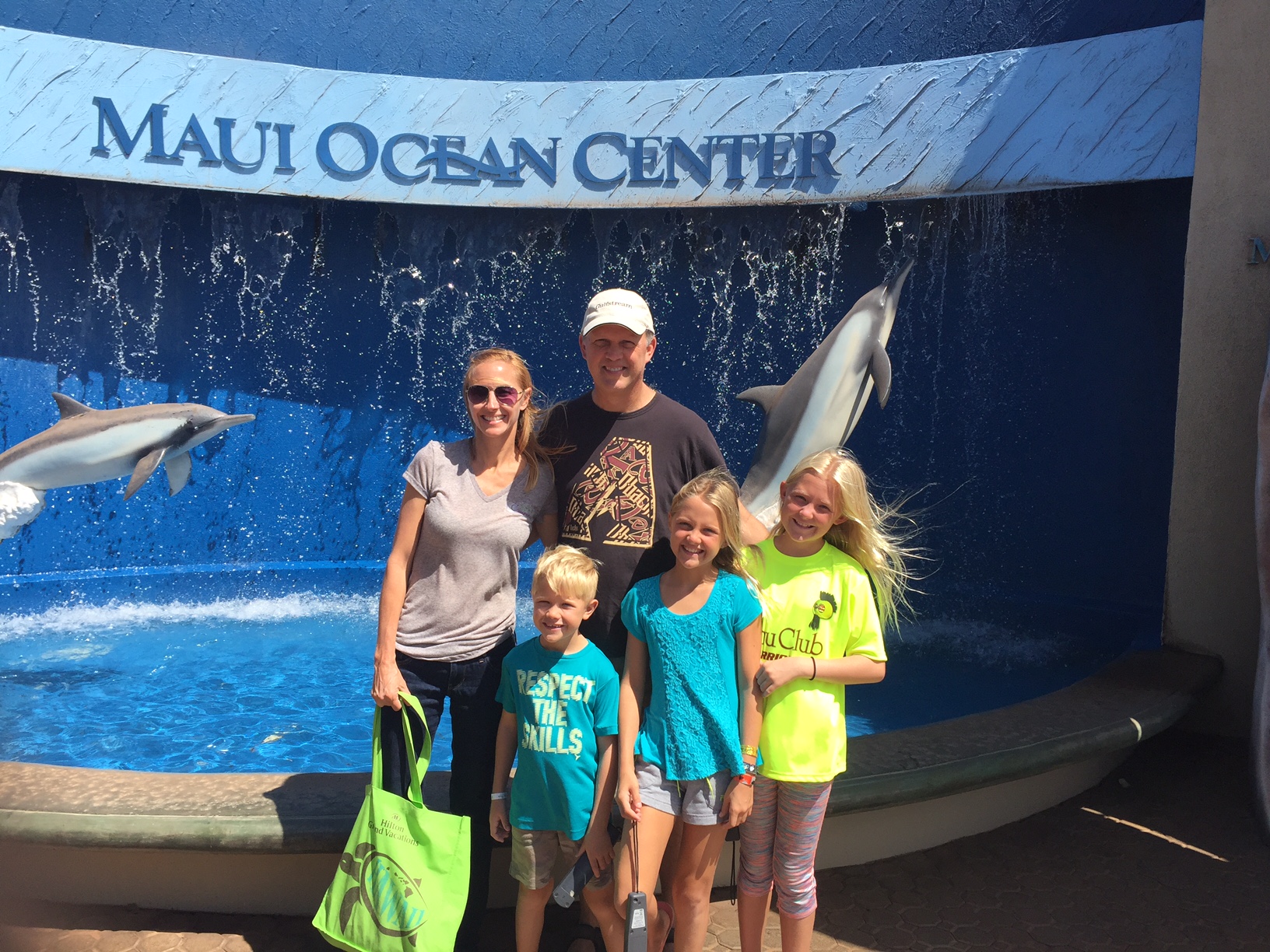 a family posing in front of the maui ocean center