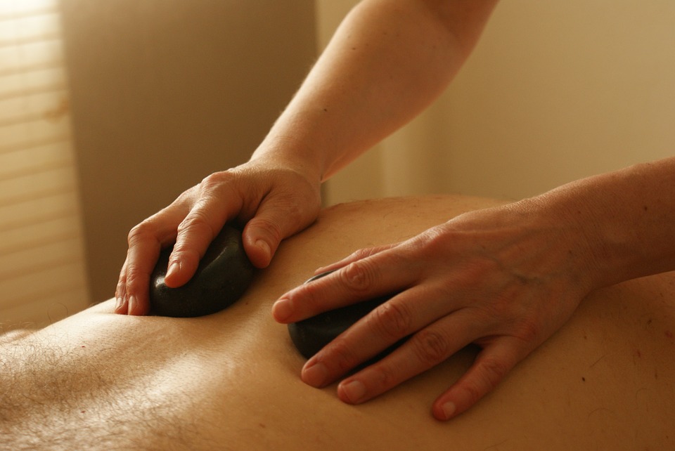 someone massaging another person with stones