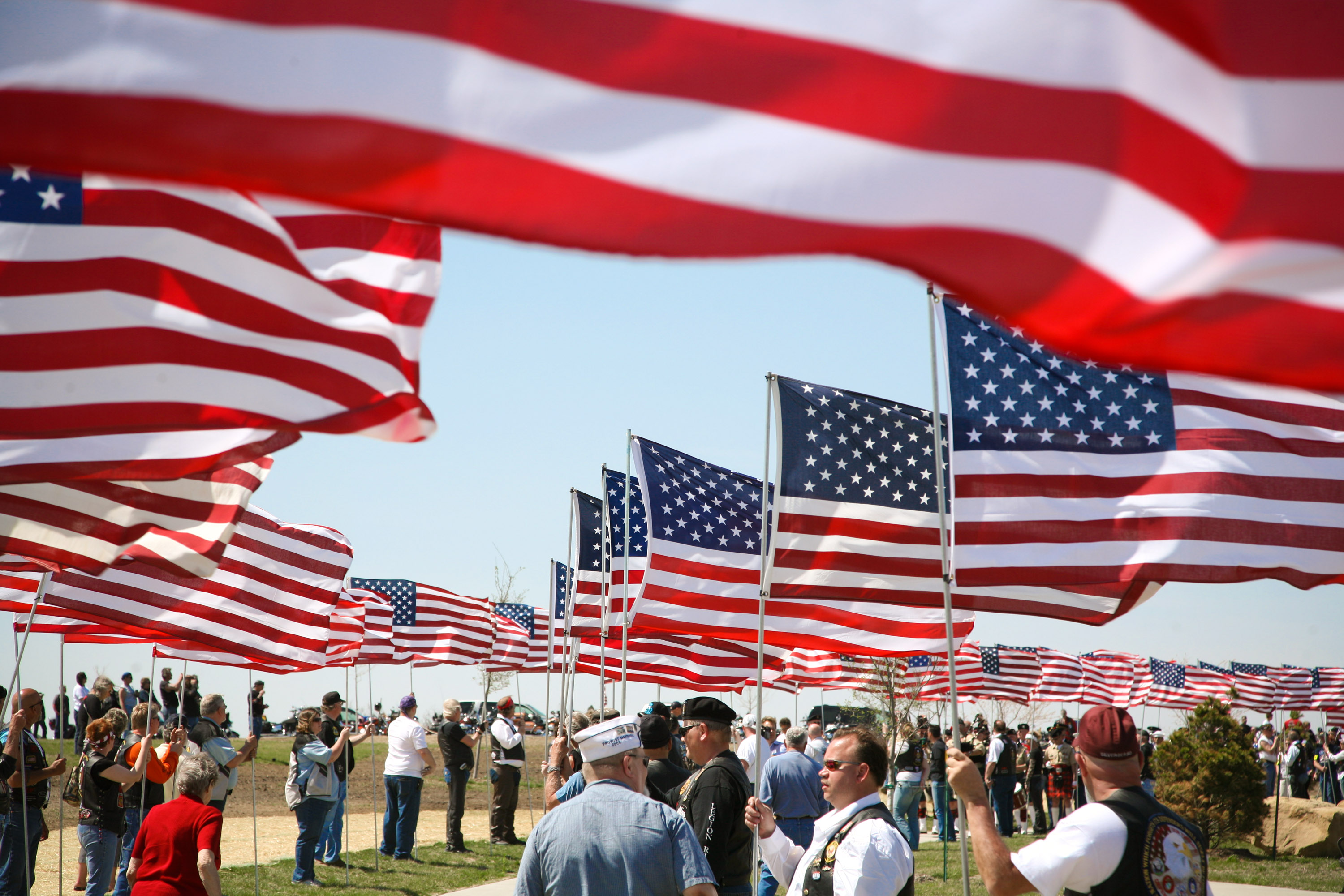 american flags waving over people