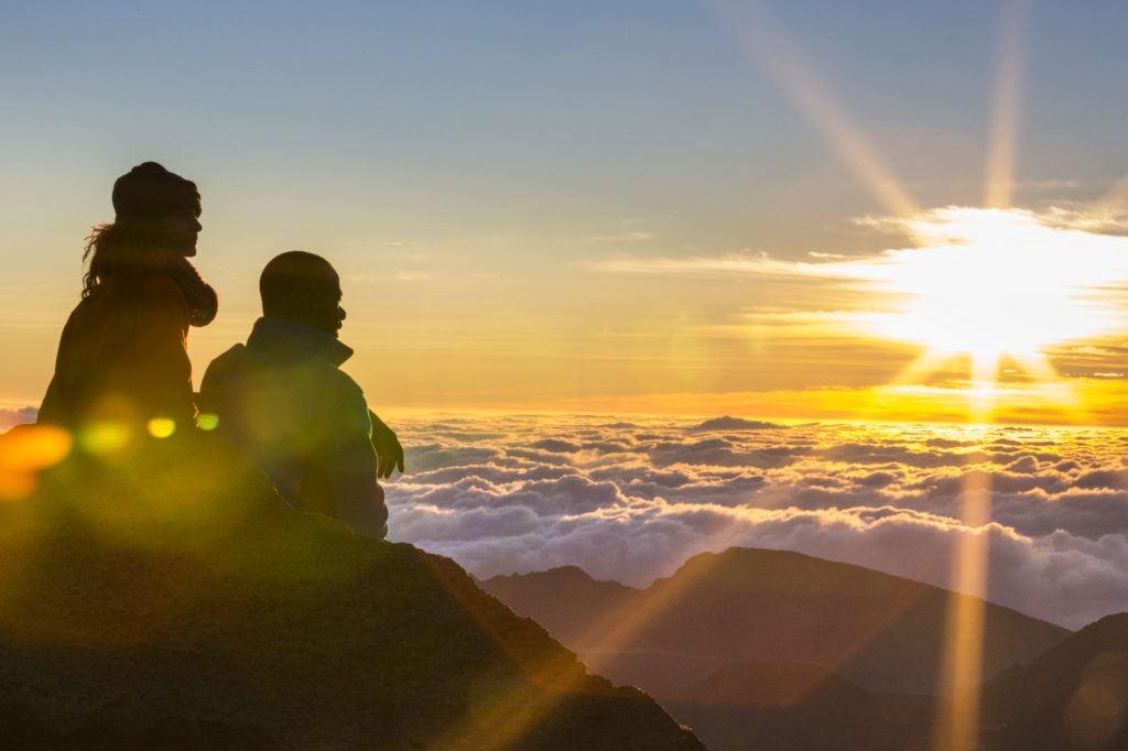 a couple watching the sunrise at haleakala national park