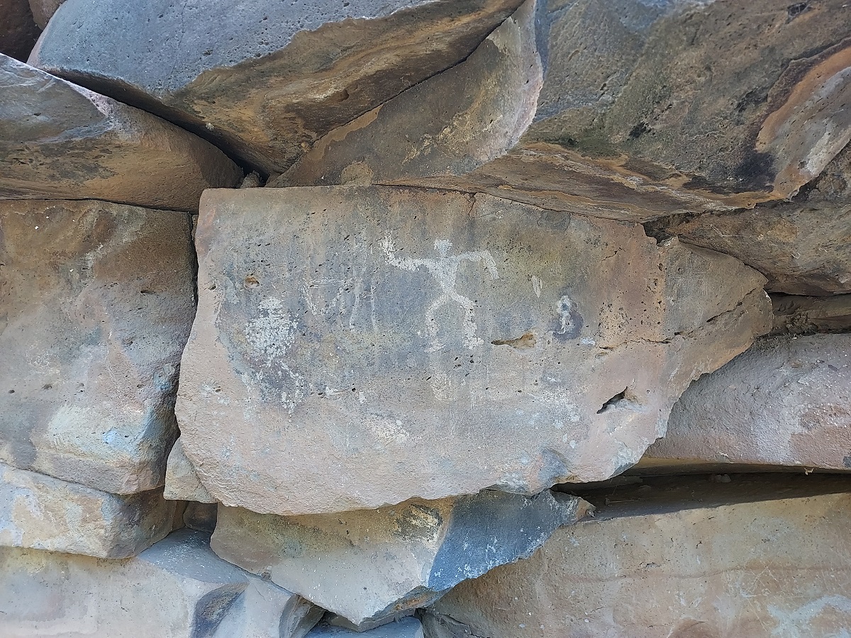 Stones with petroglyph of a sticl=k like figure