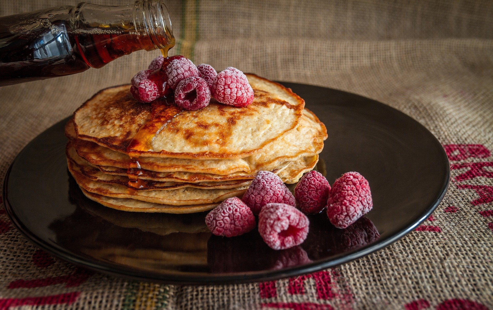 Pancakes on a dish with raspberries from Slappy Cakes on Maui