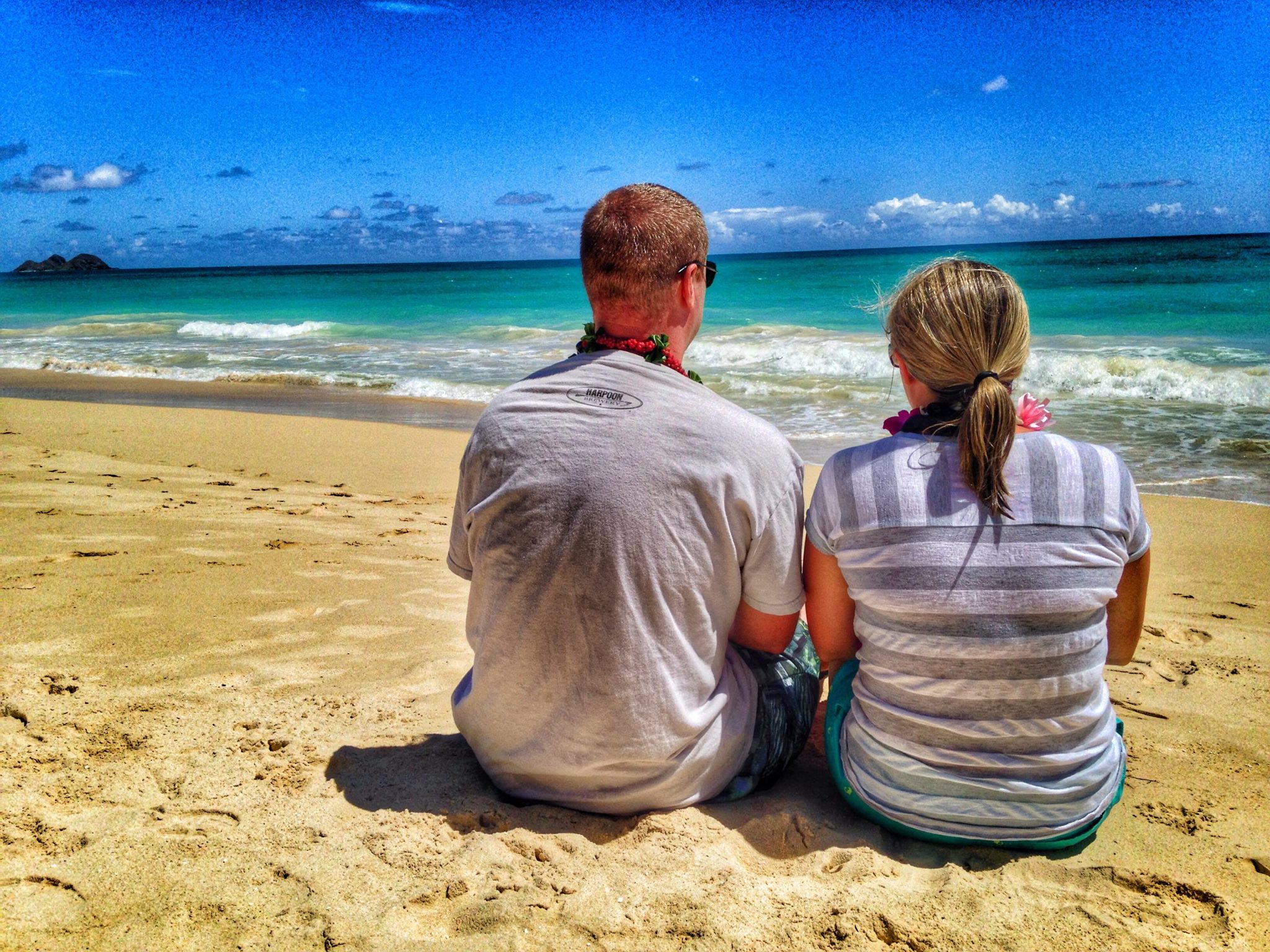 couple on a Hawaii beach looking out at the ocean