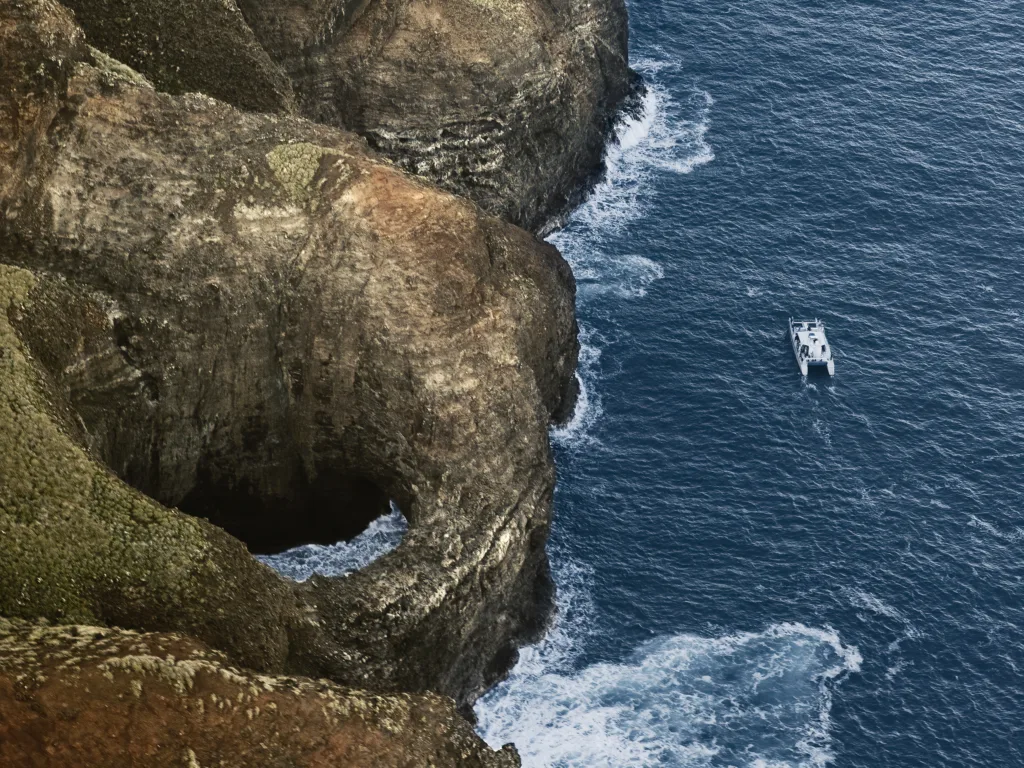 Boat snorkeling along the Na Pali Coast with steep sea cliffs and deep blue water